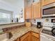 Kitchen with granite counters, wood cabinets, stainless steel microwave, and breakfast bar with a view at 2634 Andros Ln, Kissimmee, FL 34747