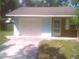 Side view of a light blue home with an attached garage, brick accent, and well-maintained landscaping at 3695 Dale Ct, Mount Dora, FL 32757
