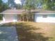 Charming single-story home with light blue siding, brick accents, mature trees, and an attached garage at 3695 Dale Ct, Mount Dora, FL 32757