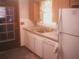 View of kitchen featuring wood cabinets, white appliances, and modern vinyl flooring at 3695 Dale Ct, Mount Dora, FL 32757