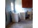 A laundry room with a washer, dryer, utility sink, and upper cabinets against blue block walls at 3695 Dale Ct, Mount Dora, FL 32757