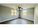 A bright bedroom with gray walls, hardwood floors, ceiling fan and dual windows that offer plenty of natural light at 101 Ellison Ave, New Smyrna Beach, FL 32168