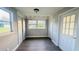 Gray hallway features hardwood flooring, natural light from a window, and white doors on either side at 101 Ellison Ave, New Smyrna Beach, FL 32168