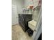 Laundry room features a utility sink, dark front loading washer and dryer, and storage shelving above at 2822 Seymore St, Lakeland, FL 33813