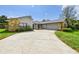 View of the home featuring stone accents and a long driveway leading to a two-car garage at 1776 E Cheryl Dr, Winter Park, FL 32792