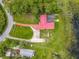 Aerial view of a home with a red roof, well-maintained lawn, driveway, and access to a tranquil lake at 318 Mitnik Dr, Deltona, FL 32738