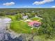 Aerial view of a home and neighborhood situated on a lake with a dock and surrounded by lush greenery at 318 Mitnik Dr, Deltona, FL 32738