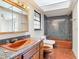 Unique bathroom featuring an orange sink, bathtub, and toilet set against a gray tiled backdrop at 318 Mitnik Dr, Deltona, FL 32738