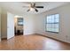 A light-filled bedroom with hardwood floors and a view into an adjacent bathroom at 318 Mitnik Dr, Deltona, FL 32738