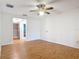 Spacious bedroom showcasing wood-look flooring with an open doorway to an ensuite bathroom at 318 Mitnik Dr, Deltona, FL 32738
