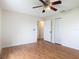 A cozy bedroom with wood floors, ceiling fan, and a door leading to additional rooms at 318 Mitnik Dr, Deltona, FL 32738