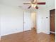 A serene bedroom featuring wood-look floors, a ceiling fan, and access to a closet and hallway at 318 Mitnik Dr, Deltona, FL 32738