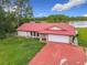 Aerial view of home with red roof, stone accents, and an attached two-car garage at 318 Mitnik Dr, Deltona, FL 32738