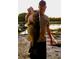 Personal displaying a massive bass fish he caught with a lake and dock in the background at 318 Mitnik Dr, Deltona, FL 32738