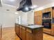 Kitchen with granite counters, a modern cooktop island, and stylish vent hood at 318 Mitnik Dr, Deltona, FL 32738