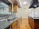 Galley kitchen featuring granite countertops, double sinks, and warm wood cabinets at 318 Mitnik Dr, Deltona, FL 32738