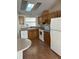 Classic kitchen with wood cabinets, white appliances, and laminate flooring at 910 Orchid St, Lady Lake, FL 32159