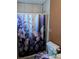 Bathroom with tile walls, floral shower curtain, and toilet at 5195 Edwina St, Orlando, FL 32811