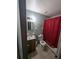 Bathroom with a shower featuring red curtain and vanity with sink at 5195 Edwina St, Orlando, FL 32811