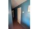 Hallway with dark blue walls, wood floors, and a closet at 5195 Edwina St, Orlando, FL 32811