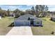 An aerial view of a home with a well-maintained lawn, three-car garage, and a serene neighborhood setting at 11331 Sw 54Th Cir, Ocala, FL 34476