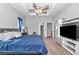 Cozy bedroom featuring a ceiling fan, tray ceiling, and convenient access to the walk-in closet and en suite bathroom at 11331 Sw 54Th Cir, Ocala, FL 34476