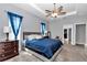 Serene bedroom featuring a tray ceiling, ceiling fan, and ample natural light from the window at 11331 Sw 54Th Cir, Ocala, FL 34476