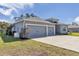 Exterior showcasing a well-maintained lawn and a spacious three-car garage at 11331 Sw 54Th Cir, Ocala, FL 34476