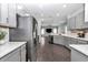 Open kitchen concept flows into living area, featuring stainless steel fridge and gray cabinets at 11331 Sw 54Th Cir, Ocala, FL 34476