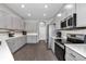 Modern kitchen with stainless steel appliances, gray cabinetry, and sleek countertops at 11331 Sw 54Th Cir, Ocala, FL 34476