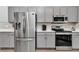 Modern kitchen featuring stainless steel appliances, gray cabinets, and quartz countertops, perfect for cooking and entertaining at 11331 Sw 54Th Cir, Ocala, FL 34476