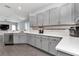 Well-lit kitchen featuring stainless steel appliances, quartz countertops, gray cabinets, and wood-look floors, great for cooking at 11331 Sw 54Th Cir, Ocala, FL 34476