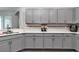 Stylish kitchen showcasing gray cabinets, complementary backsplash, and modern fixtures at 11331 Sw 54Th Cir, Ocala, FL 34476