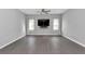 Spacious living room with wood floors, ceiling fan, and a large screen TV for relaxation and entertainment at 11331 Sw 54Th Cir, Ocala, FL 34476