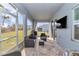 Relaxing screened-in patio with wicker furniture, TV and view of back yard at 11331 Sw 54Th Cir, Ocala, FL 34476