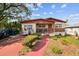 A cozy single-story home featuring a well-maintained front yard and a painted red driveway at 1222 Avenue M, Haines City, FL 33844