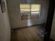 Bedroom with hardwood floors, damaged walls, and a boarded-up window at 1075 Merritt St, Altamonte Springs, FL 32701