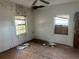 Bedroom with damaged ceiling and walls and a window boarded up with wood at 1075 Merritt St, Altamonte Springs, FL 32701
