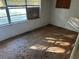 Bedroom space with wood floors, boarded window, and damaged walls and trim at 1075 Merritt St, Altamonte Springs, FL 32701