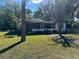 Exterior of a modest home with a screened-in porch, front lawn, and mature trees in the yard at 1075 Merritt St, Altamonte Springs, FL 32701