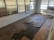 Interior view of a dilapidated room featuring damaged floors, peeling walls, and window blinds at 1075 Merritt St, Altamonte Springs, FL 32701