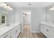 Spacious bathroom with dual vanities, white marble countertops, and wood-look floors at 5593 Sw 199Th Ct, Dunnellon, FL 34431