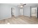 Large, empty bedroom features a ceiling fan, ensuite bathroom, and wood-look floors at 5593 Sw 199Th Ct, Dunnellon, FL 34431