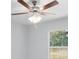Bedroom ceiling fan with decorative lighting fixture and backyard view at 5593 Sw 199Th Ct, Dunnellon, FL 34431