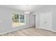 Dining room with wood-look floors, large window, neutral paint, and chandelier at 5593 Sw 199Th Ct, Dunnellon, FL 34431