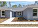 Well-lit entrance with manicured landscaping leading to a welcoming single-story home at 5593 Sw 199Th Ct, Dunnellon, FL 34431