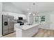 Modern kitchen with stainless steel appliances, granite counters, white cabinets, and a central island at 5593 Sw 199Th Ct, Dunnellon, FL 34431