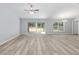 Bright living room featuring wood-look flooring, a ceiling fan, and sliding glass doors to the backyard at 5593 Sw 199Th Ct, Dunnellon, FL 34431