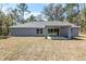 Rear exterior showcasing a covered patio, a ceiling fan, and a view of the backyard at 5593 Sw 199Th Ct, Dunnellon, FL 34431