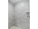 Detailed view of the shower with gray tiling, mosaic floor, and a built-in shelf at 5593 Sw 199Th Ct, Dunnellon, FL 34431